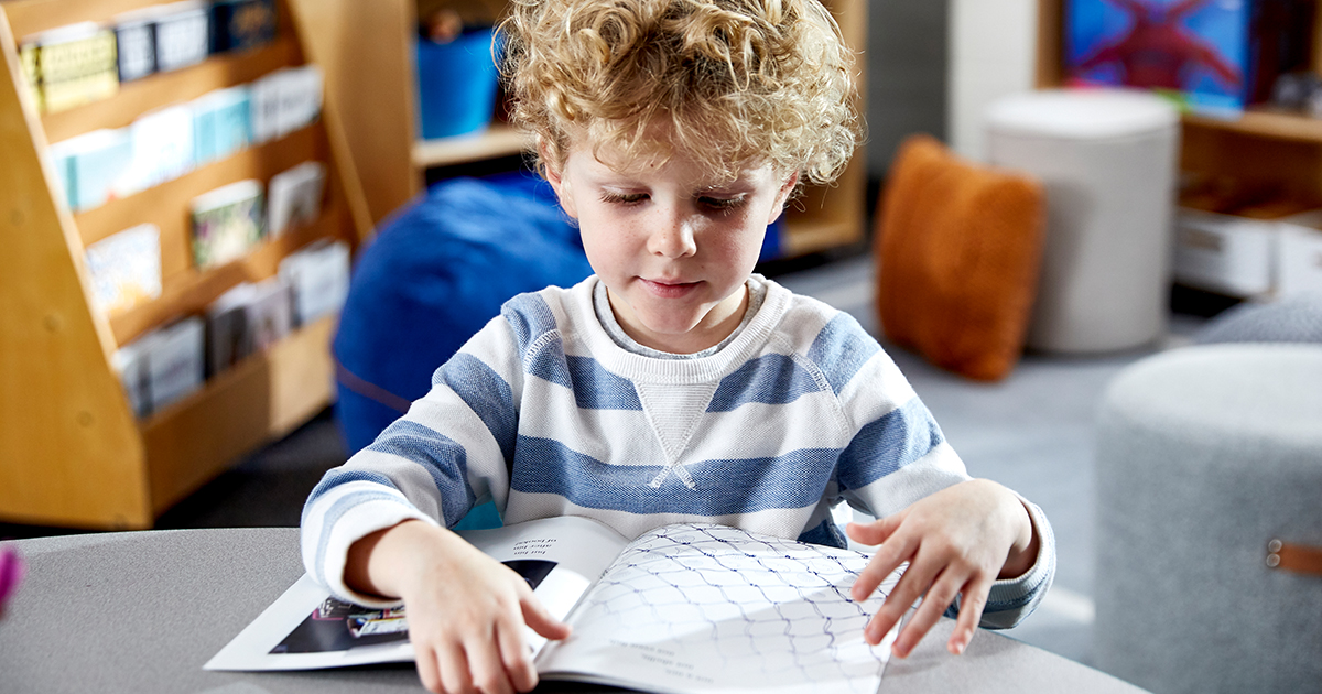 Student reading a Geodes book